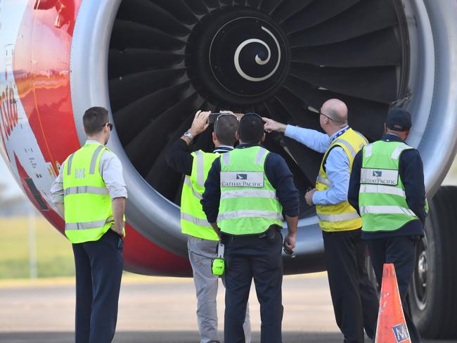 Safety Inspectors look over the engine of Air Asia flight D7207 at Brisbane Airport. Picture: AAP