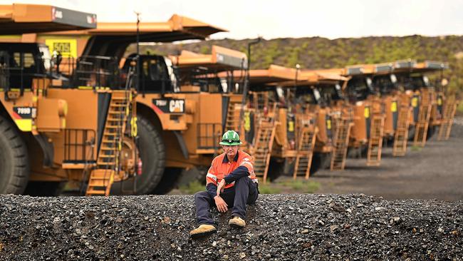 Pit operator Stewart Mills in front of the line of trucks in storage at the New Acland coal mine, outside Oakey, west of Toowoomba. Picture: Lyndon Mechielsen