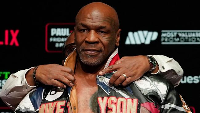 TOPSHOT - Former US heavyweight boxing champion Mike Tyson is assisted in removing his jacket during his weigh-in ahead of his heavyweight boxing match against US boxer and actor Jake Paul in Irving, Texas, on November 14, 2024. (Photo by TIMOTHY A. CLARY / AFP)