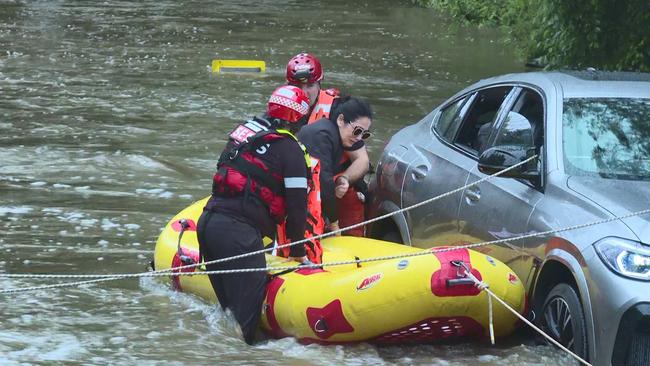 SES workers rescue another woman from the flooded BMW. Picture: TNV