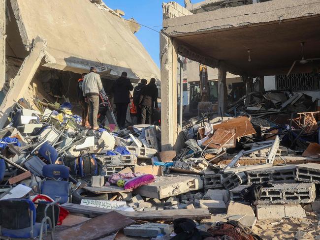 Rescuers and people search building rubble for casualties following an Israeli strike on the municipality building in Deir el-Balah in the central Gaza Strip on December 14. Picture: Eyad Baba/AFP