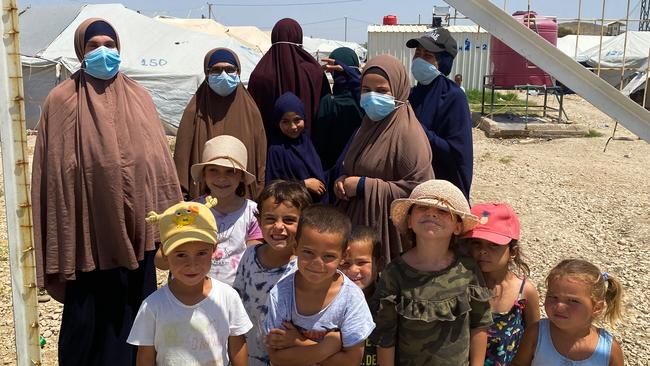 From left at back, Mariam Dabboussy, Aminah Zahab, Shayma Assaad and Bessima Assaad, photographed in al-Roj camp in June with a number of the children who are being repatriated to Australia. Aminah Zahab is not among the group returning to Australia. Picture: Ellen Whinnett