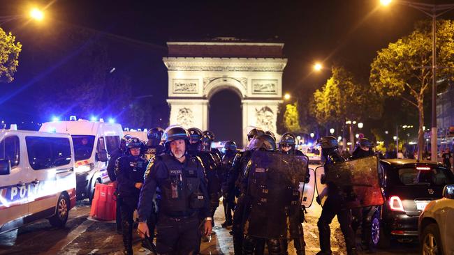 French police officers patrol in front of the Arc de Triomphe in the Champs Elysees area of Paris five days after a 17-year-old man was killed by police in Nanterre. Picture: AFP