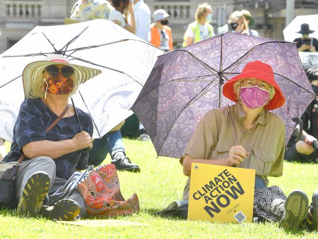 Taking shelter at the School Strike 4 Climate in Brisbane. Picture: NCA NewsWire / John Gass