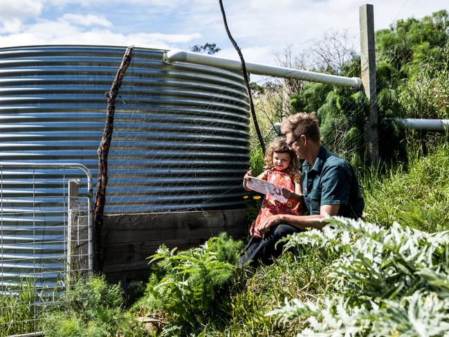 Hannah's husband Anton Vikstrom and their daughter Frida beside a rain tank at their South Hobart home. Picture: Natalie Mendham.