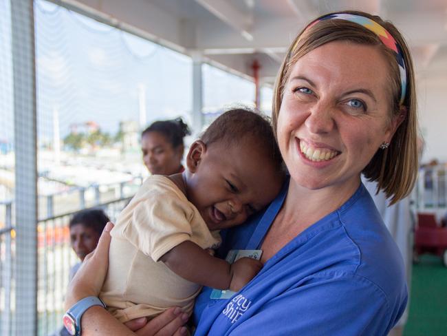 2015 Mercy Ships - Photo Credit Catrice Wulf - Ward nurse Deb Louden (AUS) holds a caregiver's child on Deck 7.