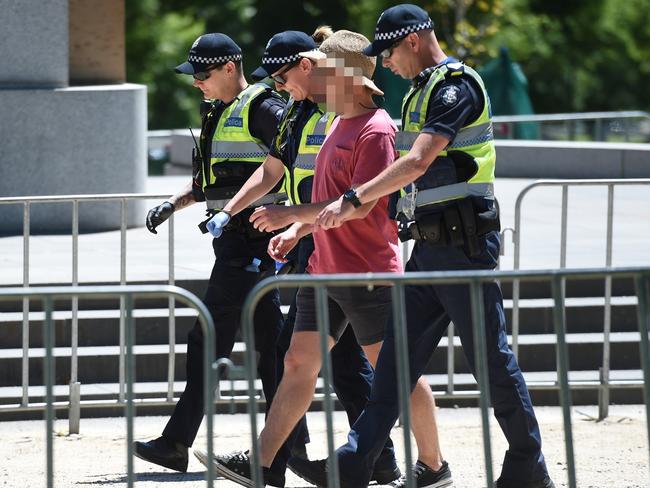 A man is taken away for a drug search at The First NYD music festival at the Sidney Myer Music Bowl. Picture: Tony Gough