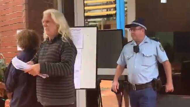 John Anderson being escorted from the Byron Shire Council chambers in Mullumbimby during the April 2021 ordinary meeting. Picture: Liana Boss