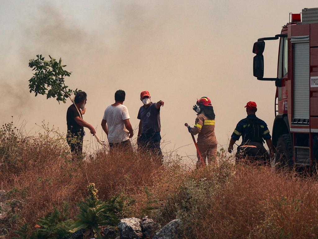 Firefighters and civilians confront a wall of smoke as wildfires burn, in the northern part of the Greek island of Corfu. Picture: AFP