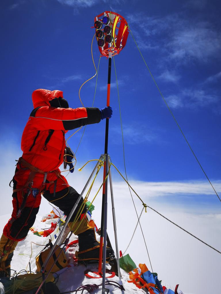 A member of a Chinese surveying team sets up a survey equipment on the summit of Mount Everest on May 27. (Tashi Tsering/Xinhua via AP)