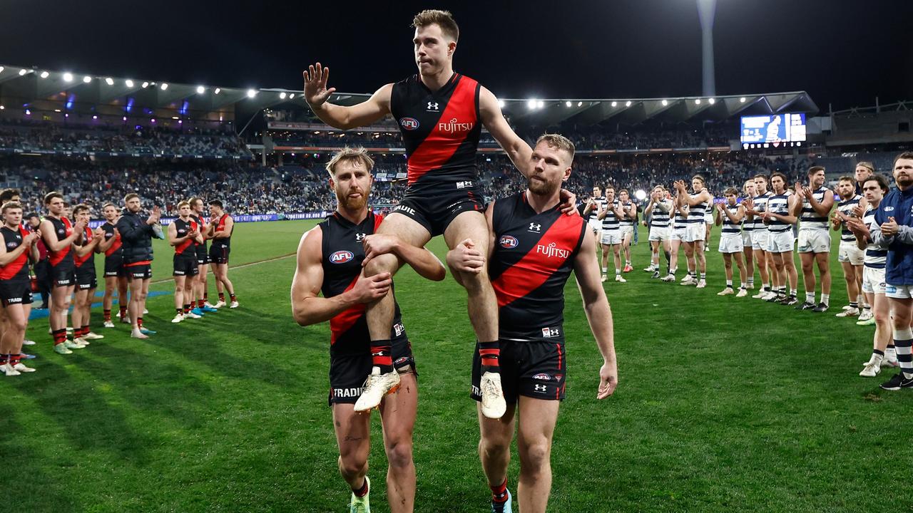 Zach Merrett of the Bombers is chaired from the field after his 200th match as players from both teams look on. (Photo by Michael Willson/AFL Photos via Getty Images)