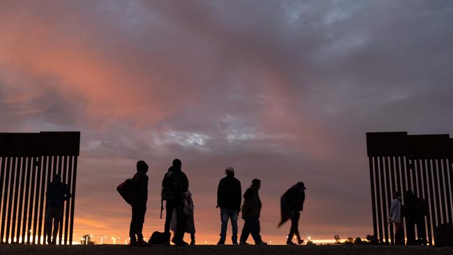 Parents-to-be from Haiti stand at a gap in the US-Mexico border wall after having travelled from South America to the United States, in Yuma, Arizona, in December 2021. Picture: John Moore/Getty Images North America/AFP