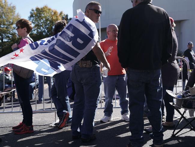 A man wears a Trump flag on his back as he waits in line for a Make America Great Again campaign rally held by US President Donald Trump in Tennessee. Picture: AFP