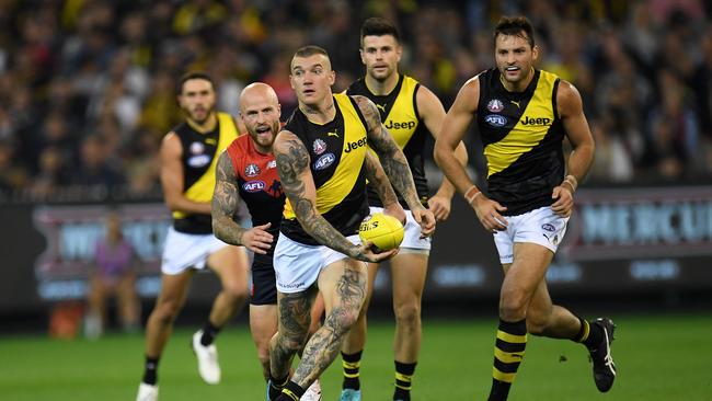 Dustin Martin of the Tigers (third from left) is seen in action during the Round 5 AFL match between the Melbourne Demons and the Richmond Tigers at the MCG in Melbourne, Tuesday, April 24, 2018. (AAP Image/Julian Smith) NO ARCHIVING, EDITORIAL USE ONLY