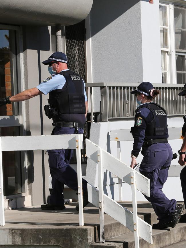 Police enter the block of units at Cooks Hill on July 22, 2021. Picture by Peter Lorimer