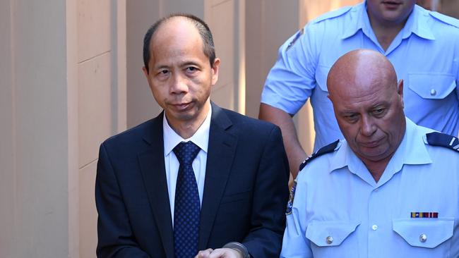 Robert Xie (left) is escorted to a prison transport vehicle at the NSW Supreme Court in Sydney in February 2017 after he was found guilty of murdering five members of his wife's family in the bedrooms of their North Epping home. (AAP Image/Paul Miller)