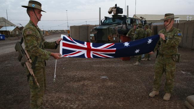 Aussie Diggers fold up the Australian flag in Taji, Iraq. Picture: Gary Ramage/News Corp Australia