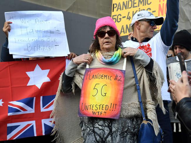 Anti-lockdown protesters hold placards on the steps of Victoria's state parliament in Melbourne. Picture: AFP