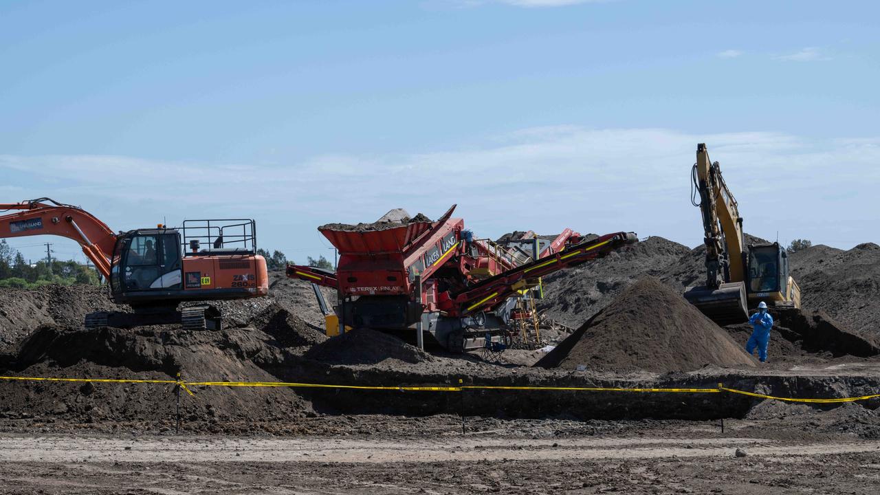 In March, workers in protective equipment move contaminated soil with asbestos signs around the building site in Murray Rd, Queenscliff. Picture: Brad Fleet