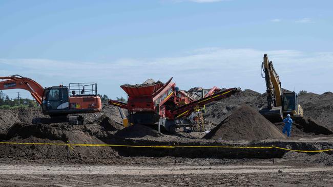 In March, workers in protective equipment move contaminated soil with asbestos signs around the building site in Murray Rd, Queenscliff. Picture: Brad Fleet