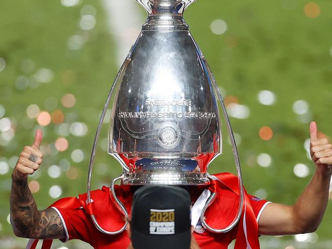 TOPSHOT - Bayern Munich's French defender Lucas Hernandez poses with the trophy upside down on his head after Bayern won the UEFA Champions League final football match between Paris Saint-Germain and Bayern Munich at the Luz stadium in Lisbon on August 23, 2020. (Photo by MATTHEW CHILDS / POOL / AFP)