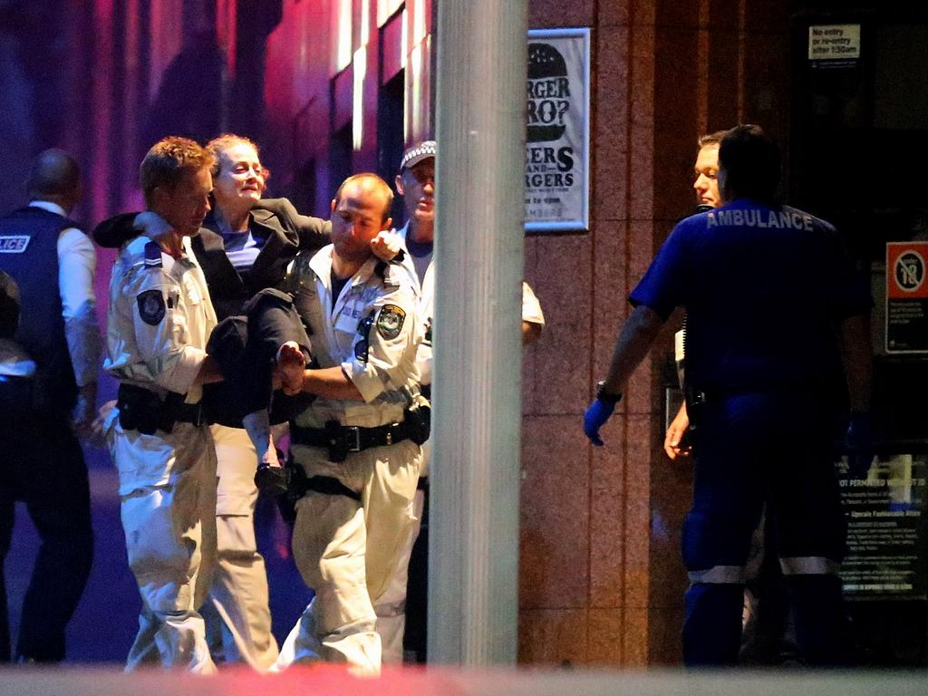 A woman is carried out of the Lindt cafe by police. Picture: Joosep Martinson (Getty Images)