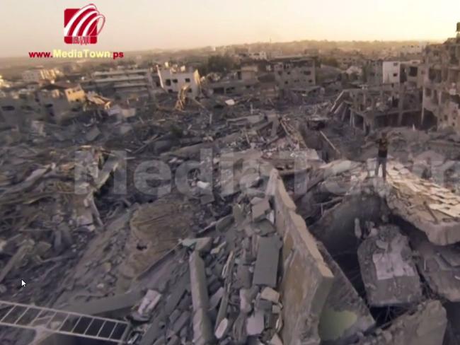 A man stands above the rubble and ruin.