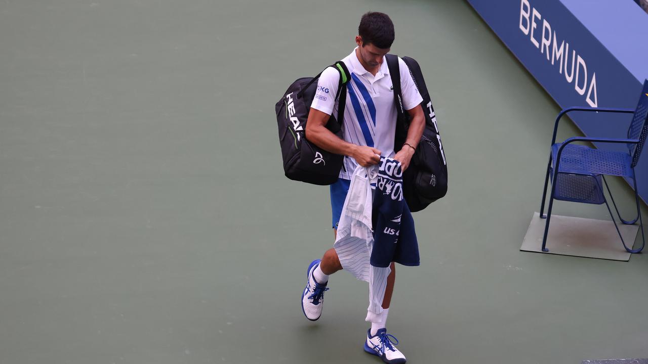 Novak Djokovic walks off the court after being defaulted due to inadvertently striking a lineswoman with a ball hit in frustration. (Photo by Al Bello/Getty Images)