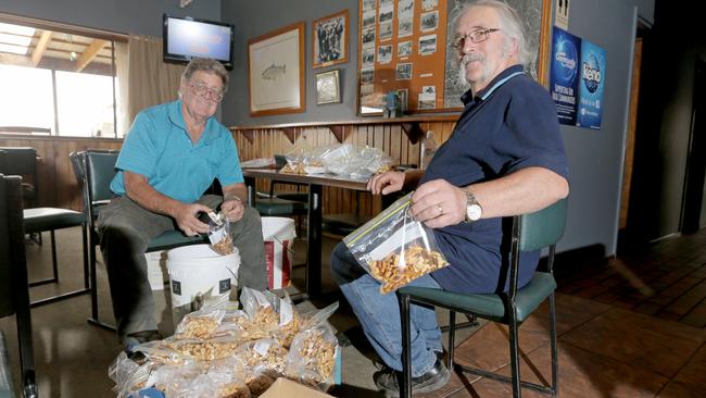 Volunteers Graham Killeen, left, and Robert Oakley help pack trail mix for crews at the Great Lake Hotel. Picture: PATRICK GEE