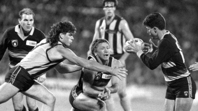 Chris McDermott fires off a handball to David Marshall during Crows’ first game.