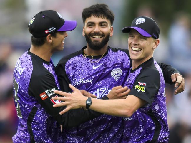 Nikhil Chaudhary of the Hurricanes is congratulated by teammates Paddy Dooley and Nathan Ellis during the BBL match between Hobart Hurricanes and Sydney Thunder at Blundstone Arena, on January 01, 2024, in Hobart, Australia. (Photo by Simon Sturzaker/Getty Images)