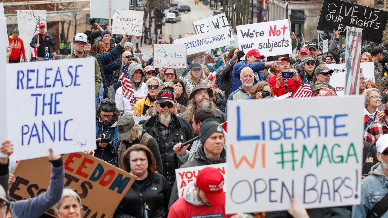 People hold signs demanding business reopen in Wisconsin’s capital Madison on Friday. Picture: Kamil Krzaczynski