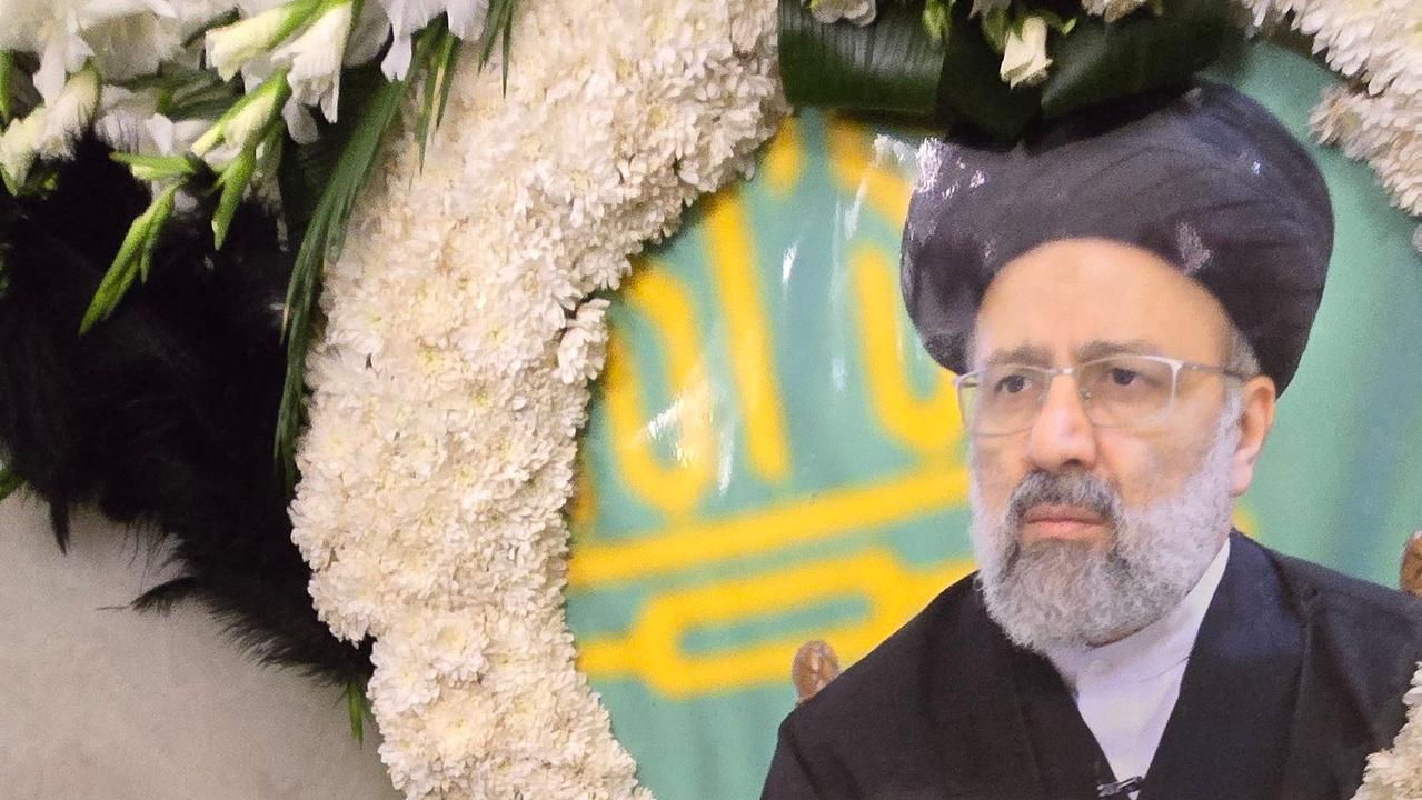 A portrait of late president Ebrahim Raisi is placed over his grave at the Imam Reza shrine during the funeral ceremony in the city of Mashhad (Photo by Mohammad Hossein ZARIFMANSHEH / FARS NEWS AGENCY / AFP)