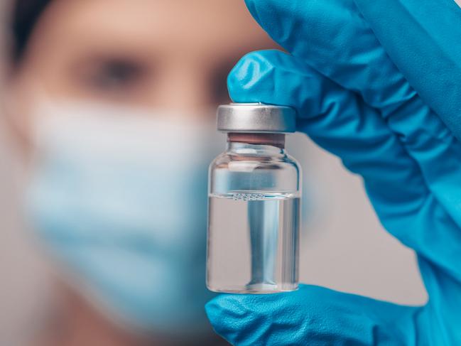 Scientist with sterile gloves and face mask holding vaccine medicine dose stock photo