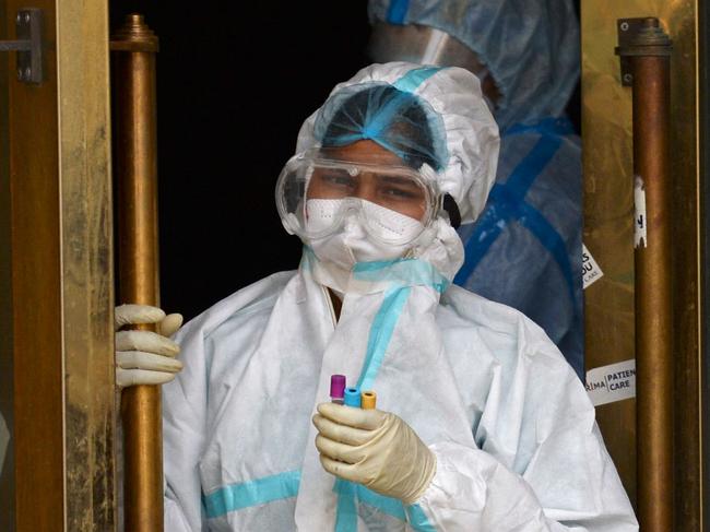 A health worker wearing protective gear holds the samples of Covid-19 coronavirus patients at a banquet hall temporarily converted into a Covid care centre in New Delhi on May 10, 2021. (Photo by Arun SANKAR / AFP)