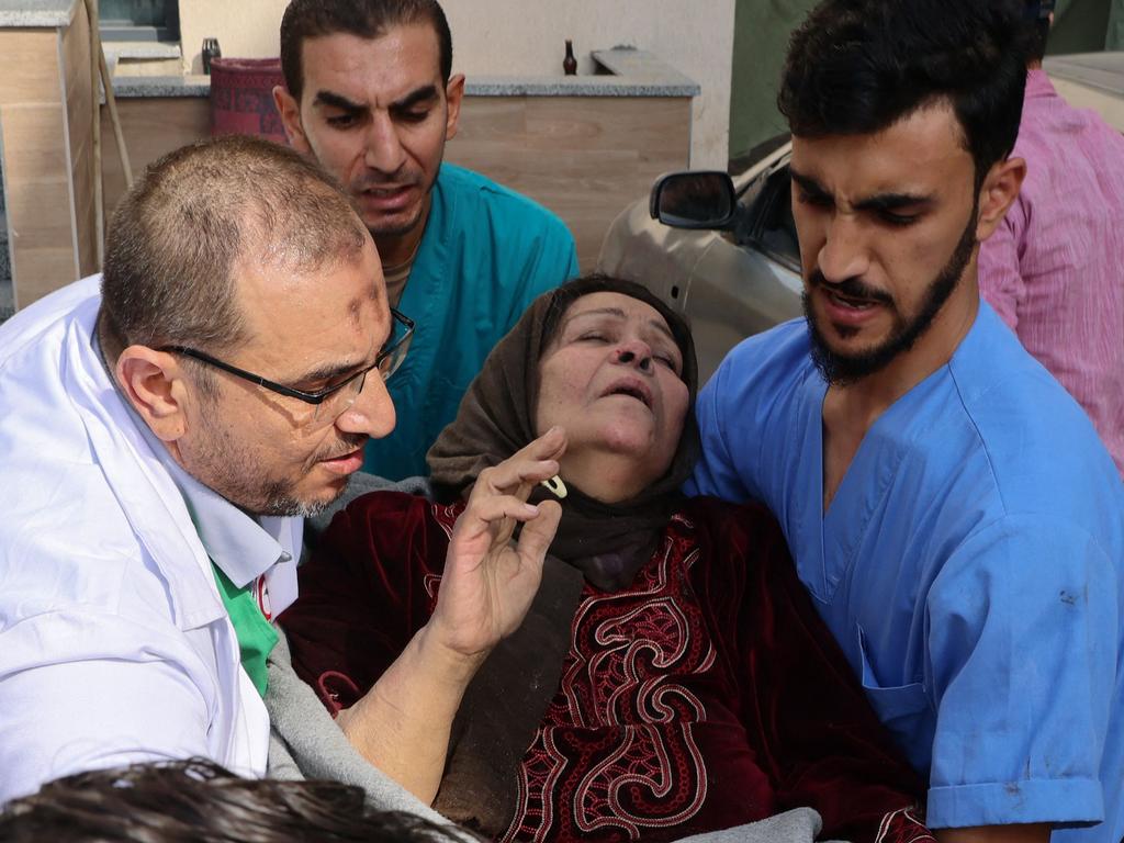 Medics carry a distressed woman outside the Kuwait hospital in Gaza, following an Israeli strike in Rafah in the southern Gaza Strip. Picture: AFP