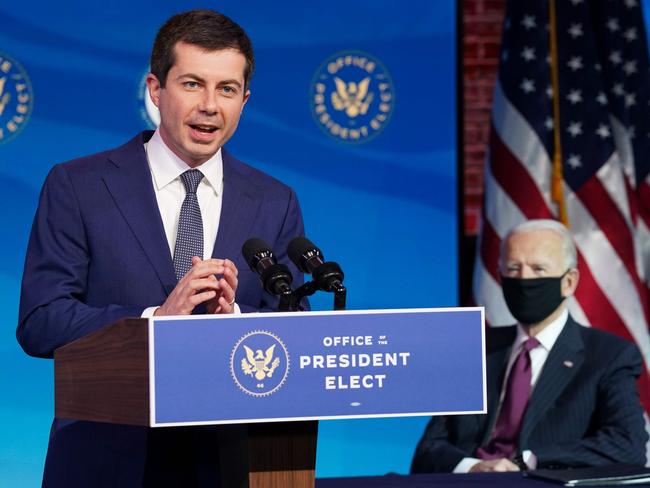 Former South Bend, Indiana Mayor Pete Buttigieg, US President-elect Joe Biden's nominee to be secretary of transportation, reacts to his nomination as Biden looks on during a news conference at Biden's transition headquarters in Wilmington, Delaware, on December 16, 2020. (Photo by KEVIN LAMARQUE / POOL / AFP)