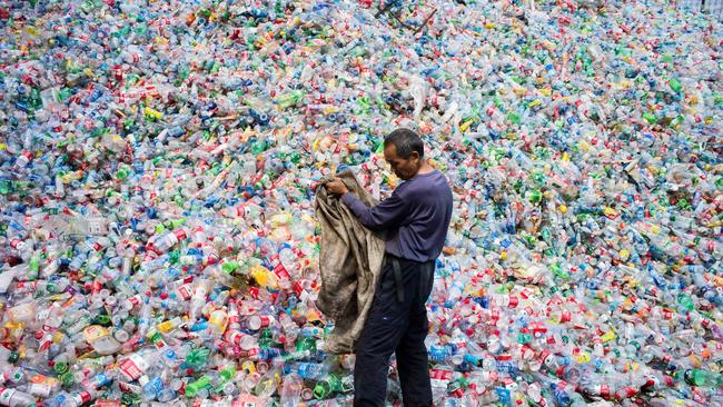 (FILES) This file photo taken on September 17, 2015 shows a Chinese labourer sorting out plastic bottles for recycling in Dong Xiao Kou village, on the outskirt of Beijing. For years China was the world's top destination for recyclable trash, but a ban on certain imports has left nations scrambling to find new dumping grounds for growing piles of garbage. The decision was announced in July and came into force on January 1, 2018 giving companies from Europe to the United States barely six months to look for other options, and forcing some to store trash in parking lots.  / AFP PHOTO / FRED DUFOUR /  - China OUT / TO GO WITH AFP STORY "CHINA-WASTE-RECYCLING" FOCUS BY BECKY DAVIS AND LILLIAN DING, WITH AFP BUREAUX IN EUROPE AND THE UNITED STATES