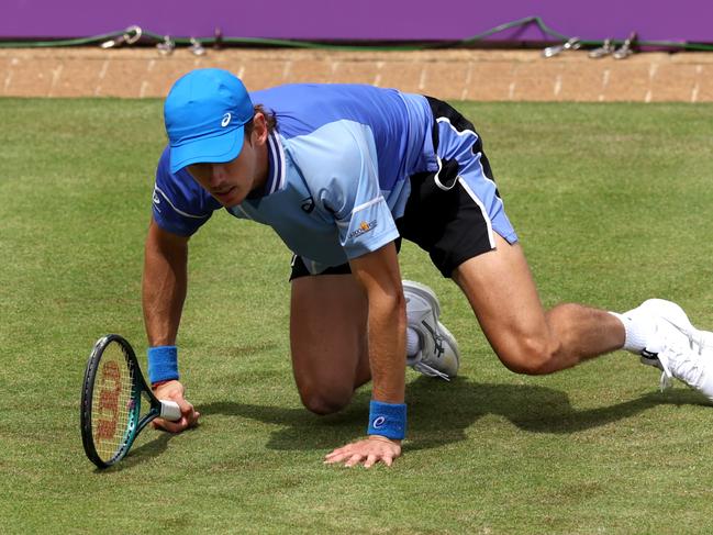 LONDON, ENGLAND - JUNE 18: Alex de Minaur of Australia falls against Lorenzo Musetti of Italy during the Men's Singles Round of 32 match on Day Two of the cinch Championships at The Queen's Club on June 18, 2024 in London, England. (Photo by Clive Brunskill/Getty Images)