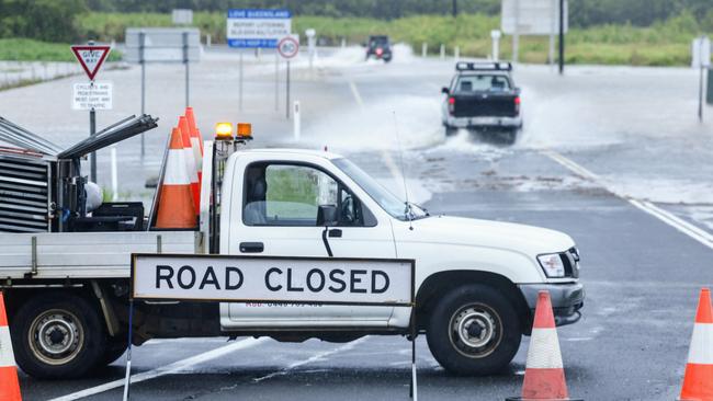 Two four wheel drives attempt to cross flood waters over Machans Beach Road, after heavy rain from ex Tropical Cyclone Jasper caused significant flooding across the Cairns region. Picture: Brendan Radke