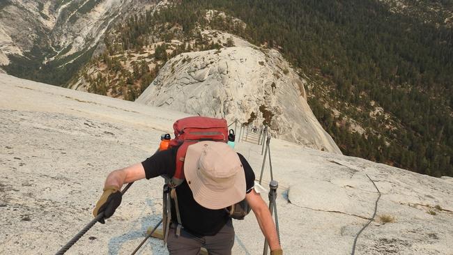 Ian Marmion descending the cables on Half Dome, Yosemite National Park, California.