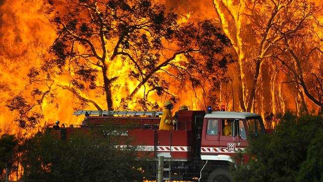 A Country Fire Authority truck silhouetted by flames in Victoria in 2009. Picture: AAP