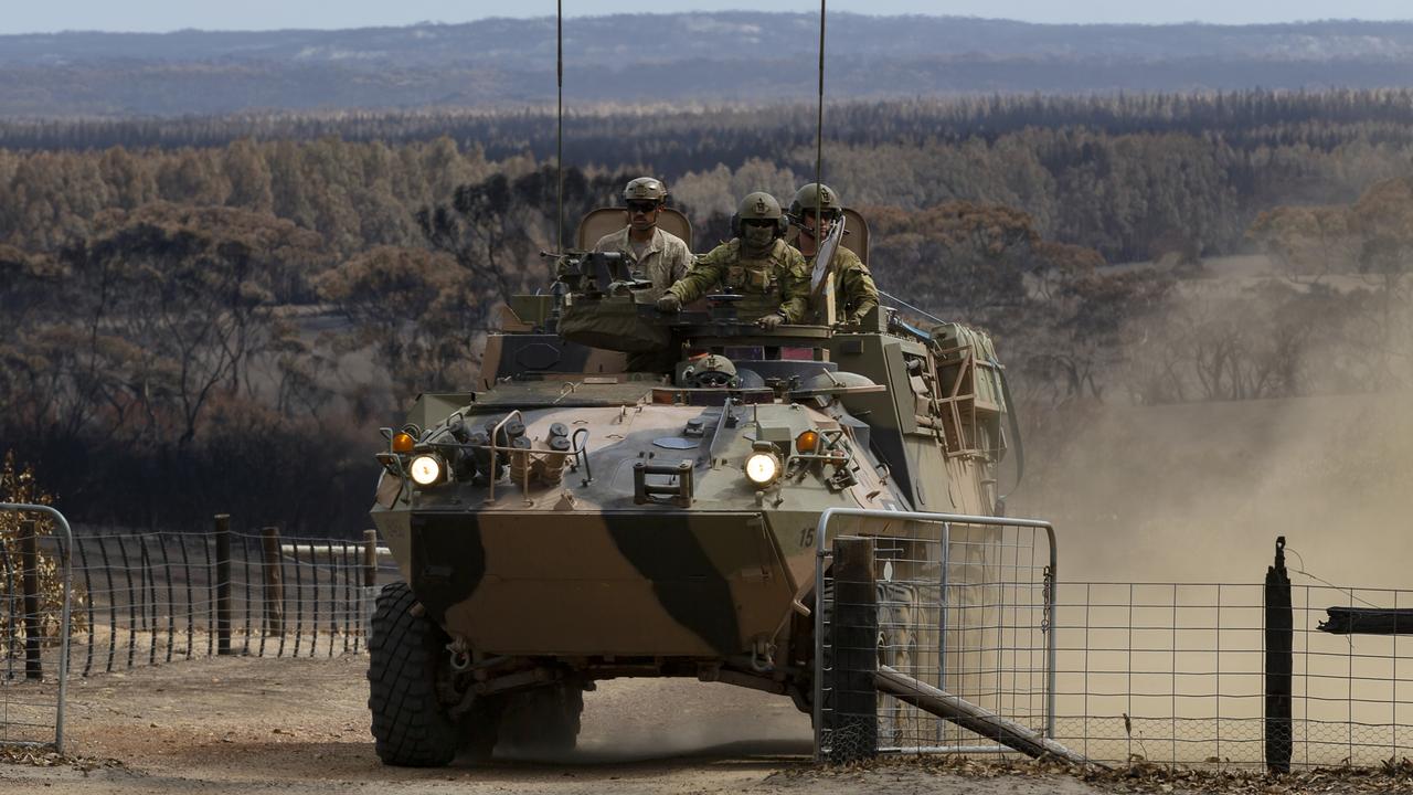 Troopers from the 1st Armoured Regiment in ASLAVs (Australian Light Armoured Vehicles) work to clear access and dispose of deceased livestock.