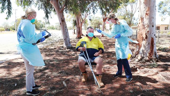 Dr West, left, makes notes as nurse Sarah O’Brien takes the temperature of Ivanhoe resident Donald Haub. Picture: John Feder