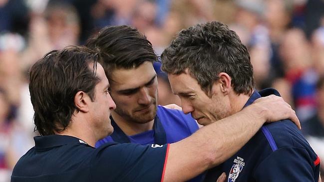 In one of football’s greatest moments, coach Luke Beveridge and acting captain Easton Wood drape a premiership medallion around the neck of injured skipper Bob Murphy in 2016.