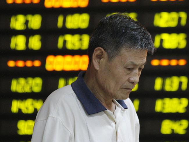 In this photo provided by China's Xinhua News Agency, a man walks past stock market quotation on display at a business lobby of a security company in Huaibei, east China's Anhui Province, Monday, July 27, 2015. The Shanghai share index dived more than 8 percent Monday as Chinese stocks suffered a renewed sell-off despite government efforts to calm the market. (Xie Zhengyi/Xinhua News Agency via AP) NO SALES