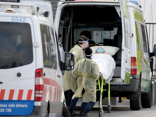 Ambulance staff transport residents from Epping Gardens Aged Care to hospital. Picture: Andrew Henshaw