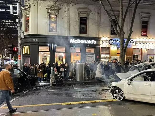 Smoke pours from one of the damaged cars as crowds gather in the aftermath of the crash. Picture: JDragono@DragonoHalim