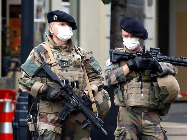 TOPSHOT - French soldiers secure the Basilica of Notre-Dame de Nice after a knife attack in Nice on October 29, 2020. - France's national anti-terror prosecutors said Thursday they have opened a murder inquiry after a man killed three people at a basilica in central Nice and wounded several others. The city's mayor, Christian Estrosi, told journalists at the scene that the assailant, detained shortly afterwards by police, "kept repeating 'Allahu Akbar' (God is Greater) even while under medication." He added that President Emmanuel Macron would be arriving shortly in Nice. (Photo by ERIC GAILLARD / POOL / AFP)