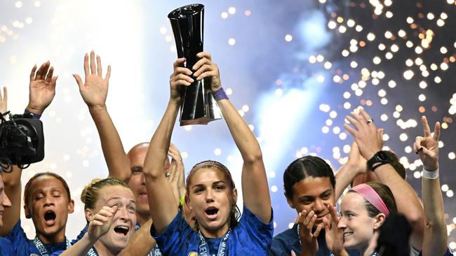 TOPSHOT - United States forward Alex Morgan (C) raises the SheBelieves Cup trophy as the United States Womenâs National Soccer Team celebrates following the 2023 SheBelieves Cup soccer match between the United States and Brazil at Toyota Stadium in Frisco, Texas, on February 22, 2023. (Photo by Patrick T. Fallon / AFP)